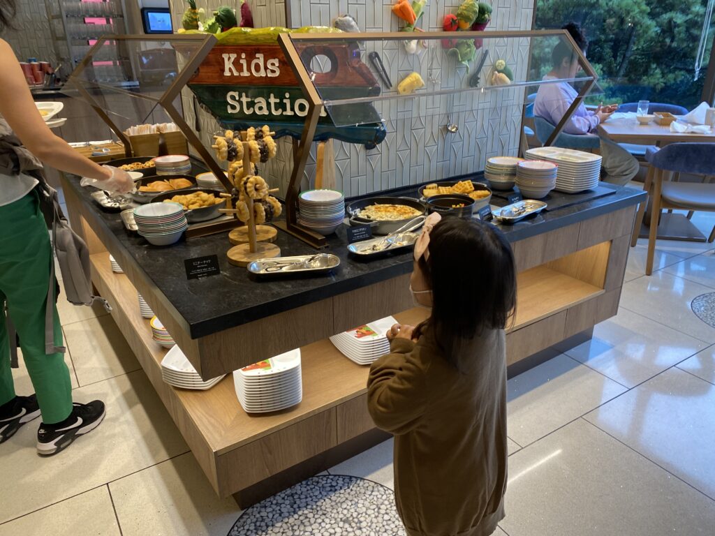 ヒルトン東京ベイの朝食のキッズステーションに立つ女の子